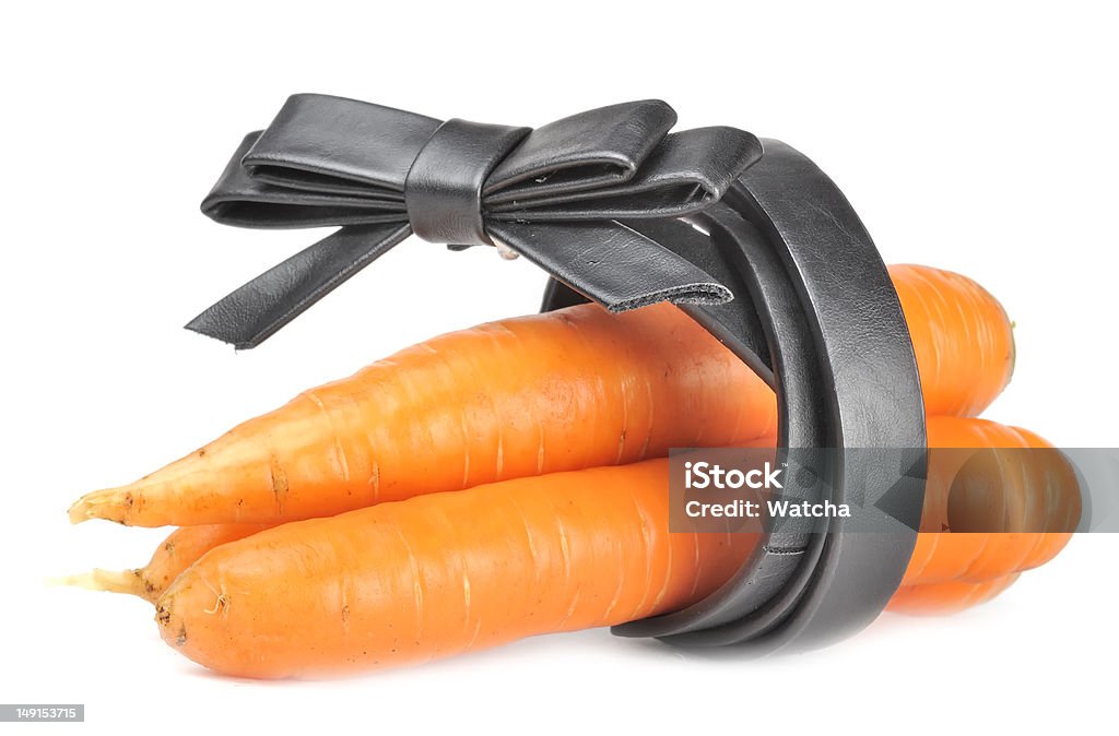 Carrots and Womens Leather Belt - Diet Concept Three carrots and a black women’s leather belt isolated on a white background - a concept of diet and healthy eating Belt Stock Photo