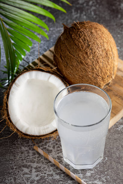 istock Glass with fresh coconut water and coconuts on the table. 1491537201