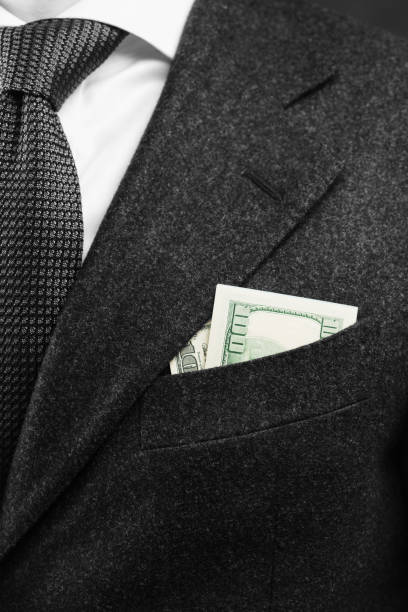 бизнесмен с долларовыми купюрами, сложенными вместо носового платка в кармане пиджака. - pocket suit close up shirt �стоковые фото и изображения