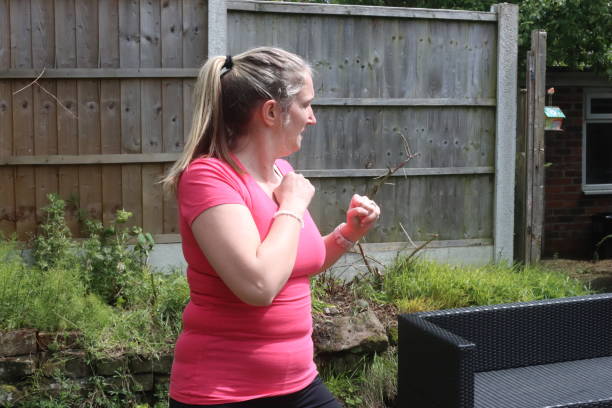 uma foto de uma mulher de meia-idade fazendo uma mistura de exercícios aeróbicos e anaeróbicos em seu jardim de casa - social media fotos - fotografias e filmes do acervo