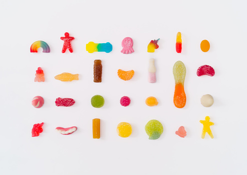 Creative pattern made of colorful gummy candies on white background. Minimal trendy concept. Flat lay, top of view.