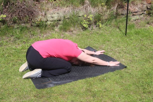 uma foto de uma mulher de meia-idade fazendo uma mistura de exercícios aeróbicos e anaeróbicos em seu jardim de casa - social media fotos - fotografias e filmes do acervo