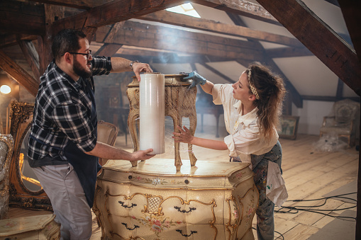 the owners of the antique store pack the furniture for shipping