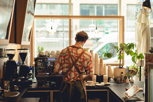 Male portrait photography of man who working as professional barista and making coffee in cafe. Lifestyle picture with people indoors.