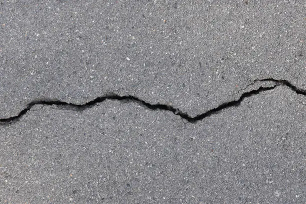 Photo of close-up asphalt road with large long crack