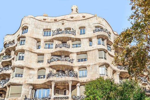 Barcelona, Spain - November 26, 2021: Facade of Casa Mila or La Pedrera building in Barcelona on an autumn sunny day. Famous architectural masterpiece, 1906. World Heritage Site by UNESCO