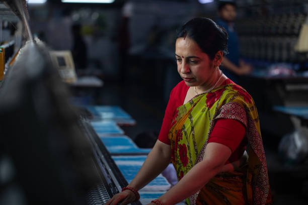 istock Female worker operating machinery in textile factory 1491549599