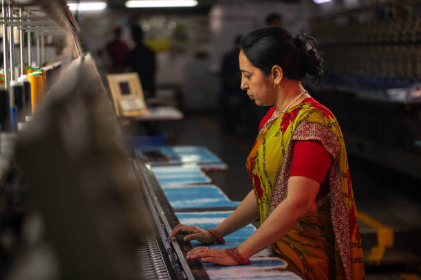 istock Female worker operating machinery in textile factory 1491549690