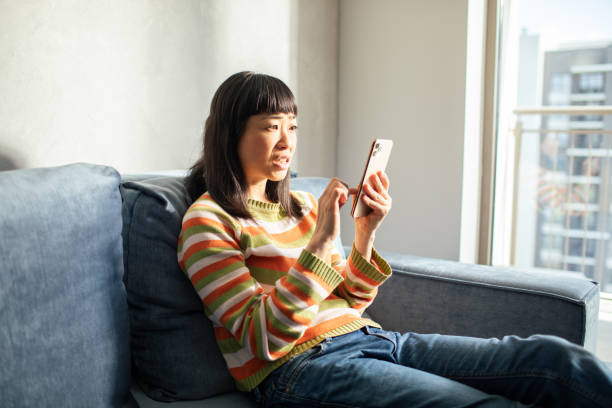istock Young Japanese Woman using a smart phone at home 1491549925