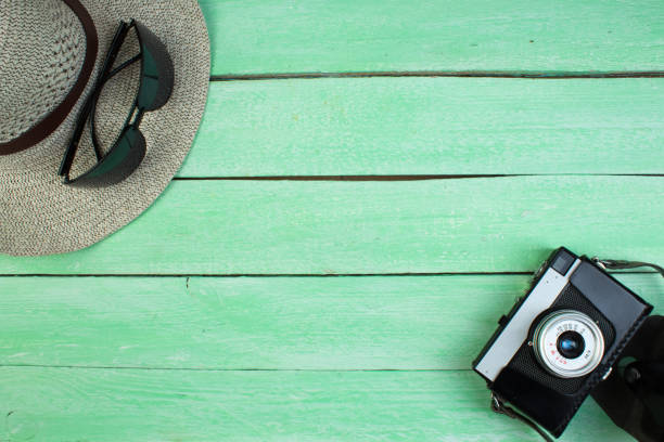 istock Hat, camera, bag, glasses, sunscreen on a summer wooden background. Top view and copy space. 1491553850