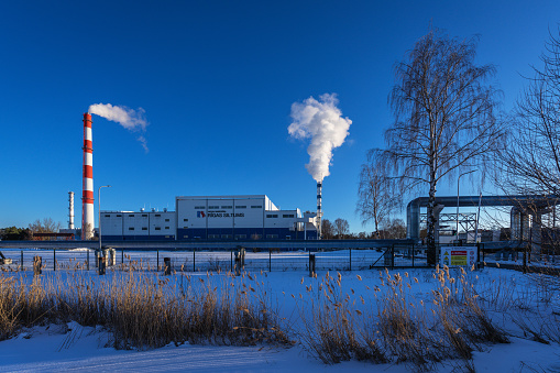 Riga, Latvia - March 9, 2023: Modern high power biofuel boiler house. A gas-fired power plant is visible in the background.