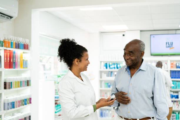 Pharmacist helping senior customer stock photo