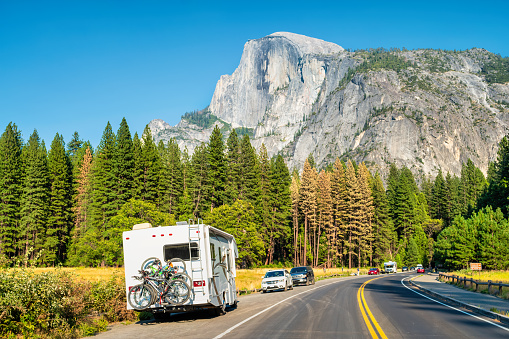 RV with bicycles in Yosemite National Park, California, USA with the landmark Half Dome in the background.
