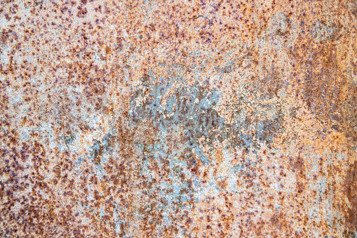 Old rusty metal texture on the surface of an iron sheet with pitting.