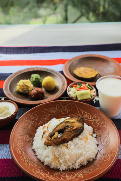istock Khuder Bhat, Hilsa Khichuri Combo with salad, eggplant, borhani and Chui Pitha served in dish isolated on mat top view of indian and bangladeshi food 1491566354