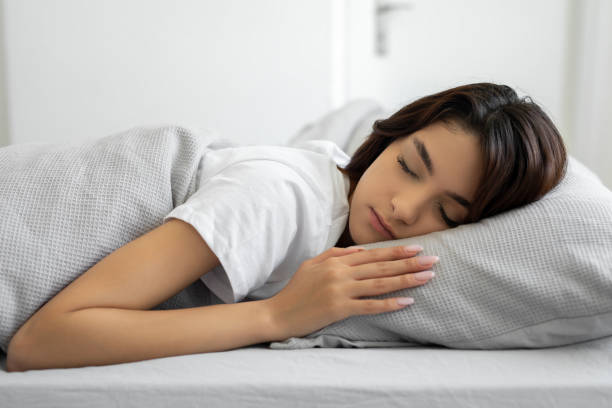 istock Woman sleeping peacefully in her bedroom 1491567459