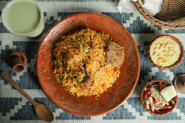 istock Mutton Kacchi biryani with salad, borhani and Chui Pitha served in dish isolated on mat top view of indian and bangladeshi food 1491568427