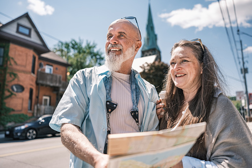 Senior  Couple sightseeing  the city. Both dressed in casual clothes . Exterior of urban area of North American city.