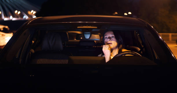 istock Woman driver sitting in car doing make up using lipstick. 1491573352