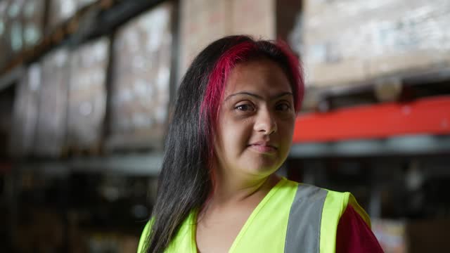 Portrait of disabled young woman working in a warehouse