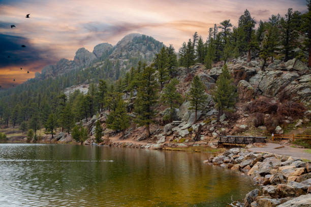 Lily Lake in Colorado Wide angle view of Lily Lake and its rocky shoreline in Colorado, against a colorful sky. colorado rocky mountain national park lake mountain stock pictures, royalty-free photos & images