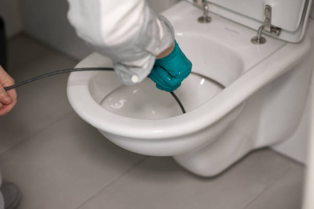 Man cleaning overflowing broken toilet. clogged toilet. stock photo