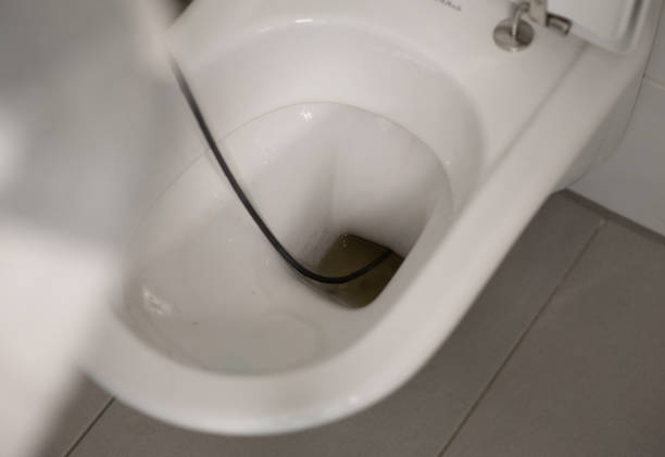 Man cleaning overflowing broken toilet. clogged toilet. stock photo