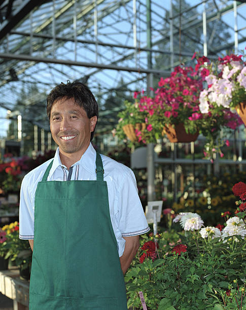 istock Nursery worker surrounded by plants in greenhouse, portrait 149158186