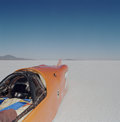 Racecar driver lying in streamliner car, elevated view