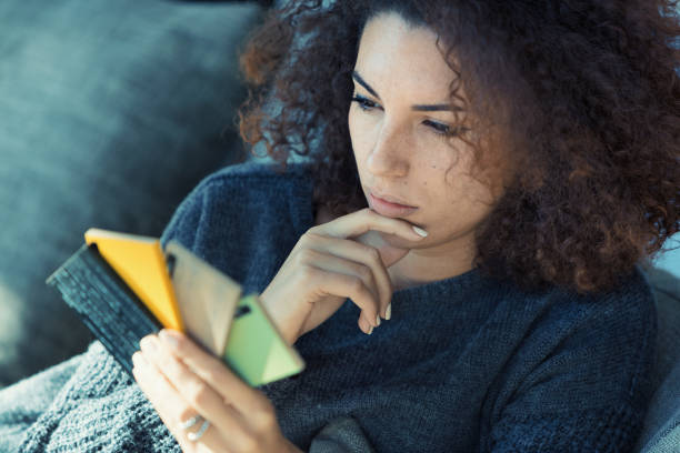 istock Ethnic woman on couch, selecting colors, amused 1491589205