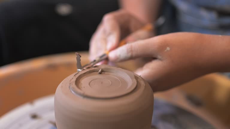 Professional craftsman potter making jug on potter wheel circle