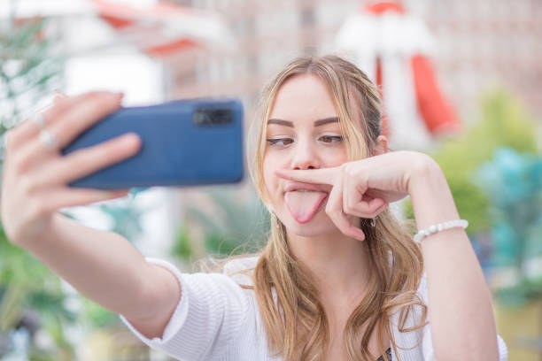 istock Young woman taking selfie on street 1491598886