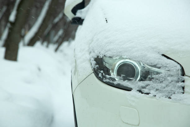 reflektor samochodowy z soczewką światło ksenonowe pokryte śniegiem w zimową pogodę, zaspy śnieżne na drodze. zbliżenie detalu pojazdu. - car winter road reflector snow zdjęcia i obrazy z banku zdjęć