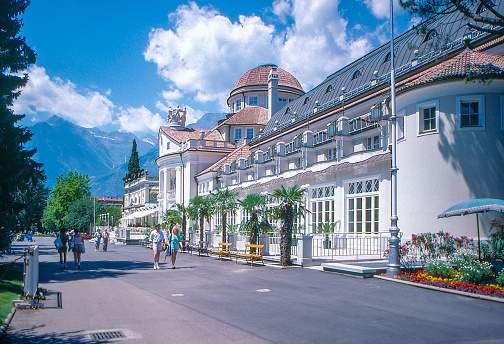 Tourists are walking on Passeggiata Lungo Passirio. 1989 old Positive Film scanned, the view of Merano, South Tyrol, Italy.