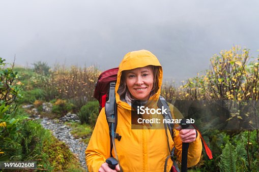 istock Positive adventurous woman with hiking equipment exploring wilderness. 1491602608