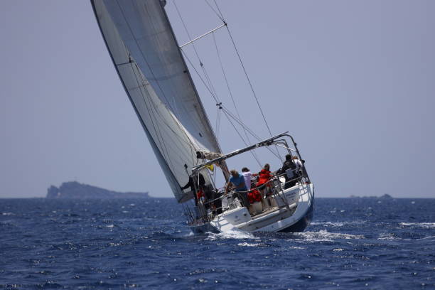 segelboote segeln bei windigem wetter im blauen wasser der ägäis - sailboat storm teamwork competition stock-fotos und bilder