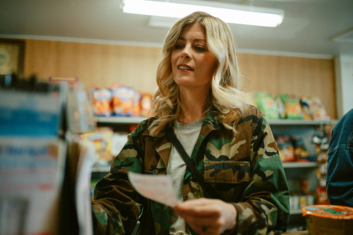 Woman shopping for a lottery ticket in a small convenience store in Los Angeles, California.