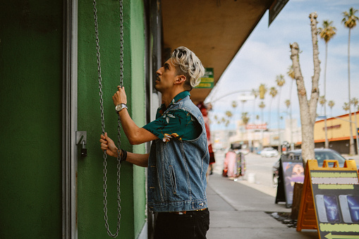 owner opening a small convenience store in the morning in Los Angeles, California.