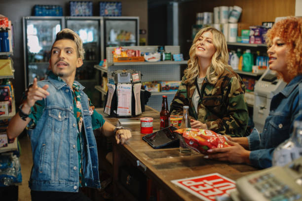 shopping in a local convenience store in LA Group of women hanging out, shopping for drinks and snacks in a local convenience store in Los Angeles, California. liquor store counter photos stock pictures, royalty-free photos & images