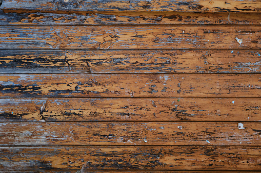 Old weathered rustic wooden wall with worn out peeling paint, grunge wood background or texture
