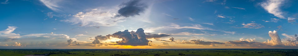 Panorama Top view Aerial photo from flying drone over village in Thailand.Top view beautiful Sunset with dramatic sky clouds.Sunrise with cloud over rice field.