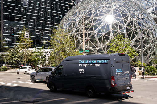 Seattle, USA - May 8, 2023: Late in the day an Amazon prime delivery truck passing by the Amazon HQ.