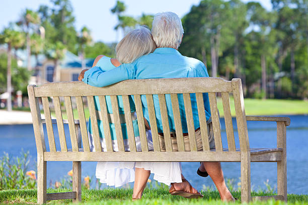 istock Rear View Senior Couple Sitting On Park Bench Embracing 149161635