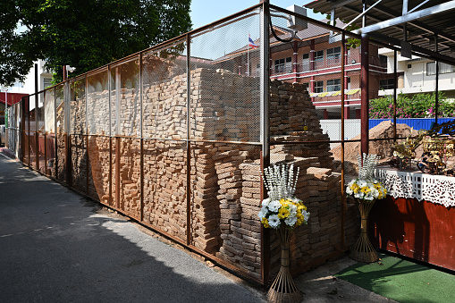 Chiangmai, Thailand – May 20, 2023: the old bricks from collapsed pagoda stacked in the fence cover all around the maintenance site.\n\nupdate on the collapse of Phra That Sri Suphan, going on maintenance of Phra That Sri Suphan pagoda in Wat Sri Suphan on Wua Lai Road collapsed in September 2022. Wat Sri Suphan Temple is placed in the Chiangmai province of Thailand.