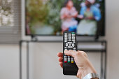 Woman switching channels with remote control