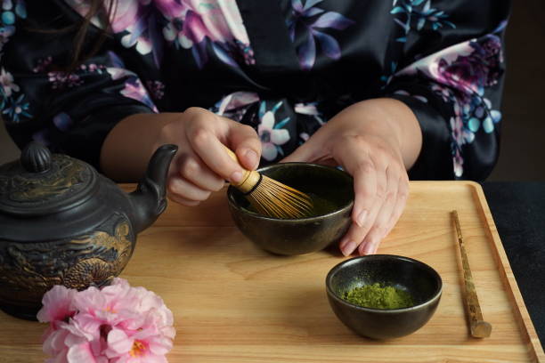 istock Woman tea master in kimono performs tea ceremony. Matcha green tea powder with a bamboo whisk and scoop as used in a traditional Japanese tea ceremony. 1491639241