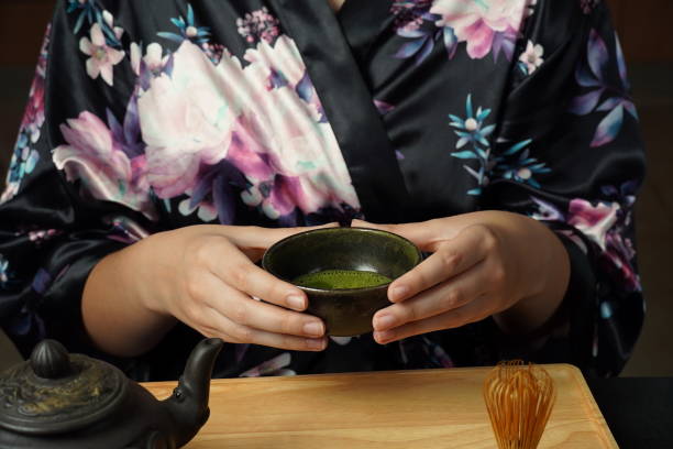 istock Woman tea master in kimono performs tea ceremony. Matcha green tea powder with a bamboo whisk and scoop as used in a traditional Japanese tea ceremony. 1491639243