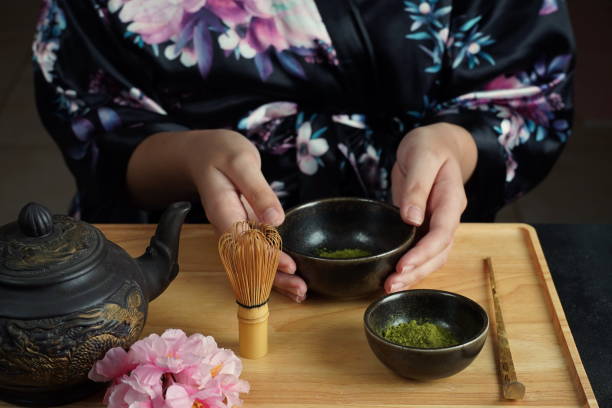 istock Woman tea master in kimono performs tea ceremony. Matcha green tea powder with a bamboo whisk and scoop as used in a traditional Japanese tea ceremony. 1491639249