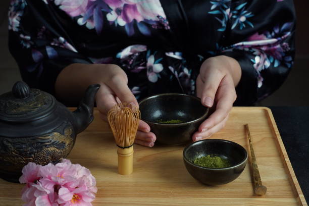istock Woman tea master in kimono performs tea ceremony. Matcha green tea powder with a bamboo whisk and scoop as used in a traditional Japanese tea ceremony. 1491639251