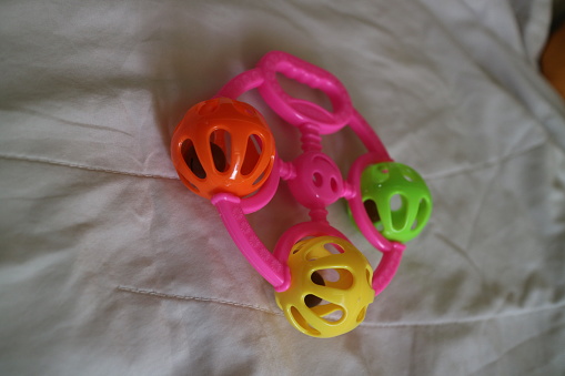 a photo of a colorful toddler toy that can make a tinkling sound with a pink handle